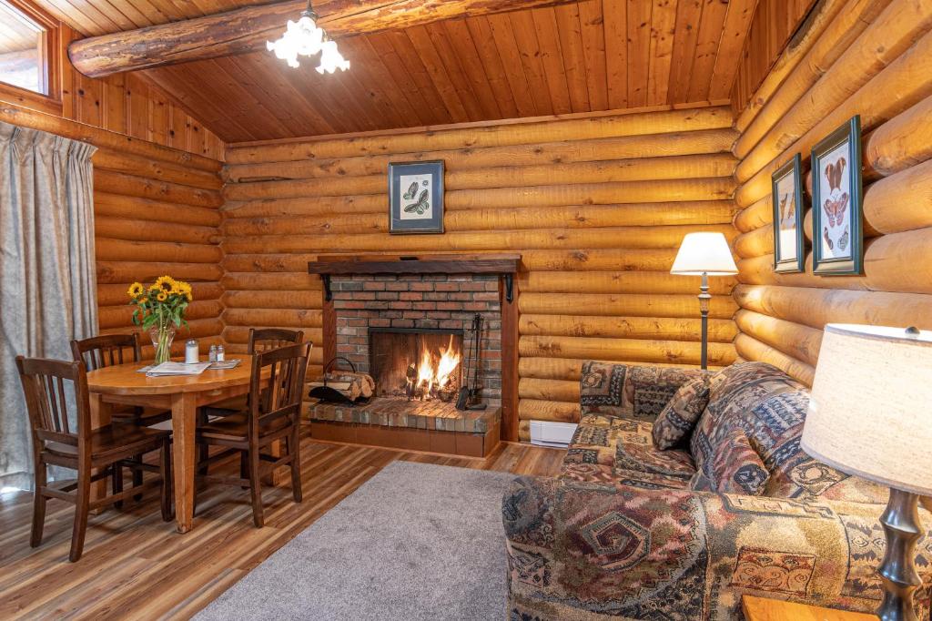 a living room with a fireplace in a log cabin at Cusheon Lake Resort in Ganges
