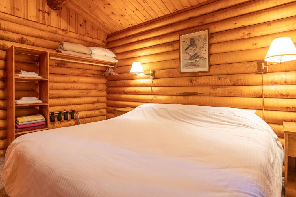 a bedroom with a bed in a log cabin at Cusheon Lake Resort in Ganges