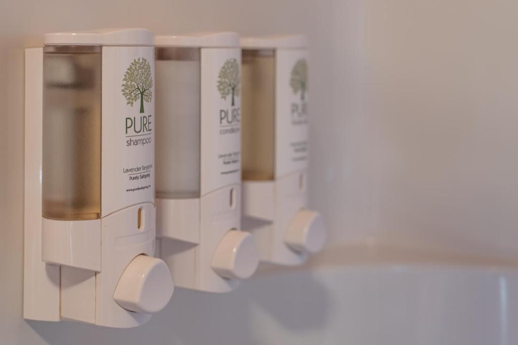 a row of white soap dispensers in a row at Cusheon Lake Resort in Ganges
