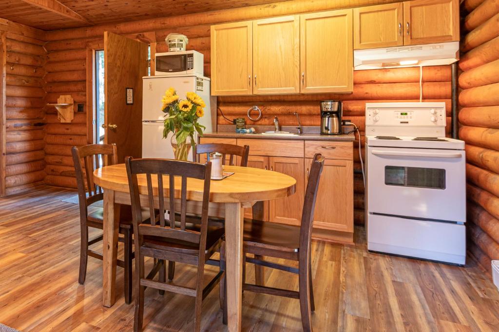 a kitchen with a table and chairs and a stove and refrigerator at Cusheon Lake Resort in Ganges