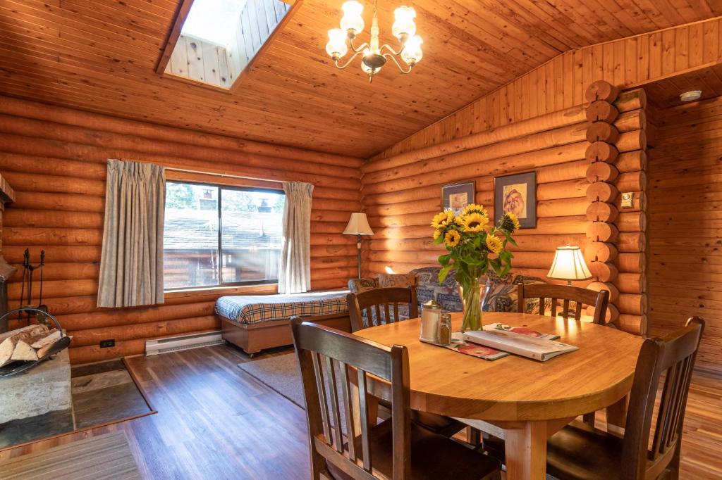 a dining room with a table in a log cabin at Cusheon Lake Resort in Ganges