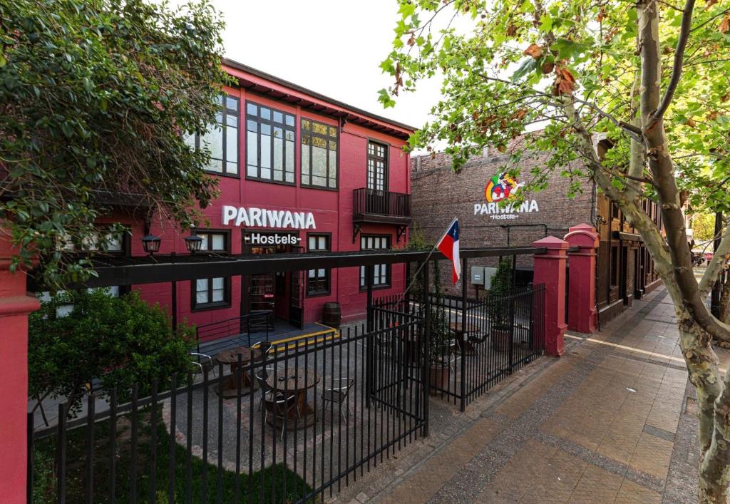 ein schwarzer Zaun vor einem roten Gebäude in der Unterkunft Pariwana Hostel Santiago in Santiago