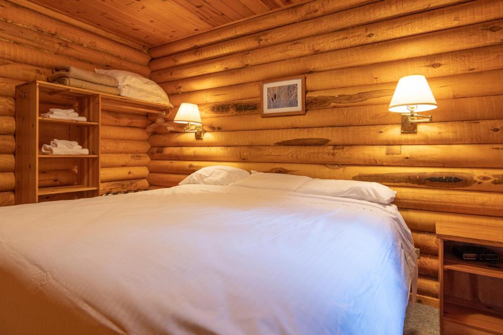a bedroom with a bed in a log cabin at Cusheon Lake Resort in Ganges