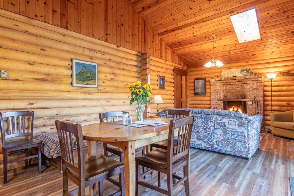 a dining room with a table and chairs and a fireplace at Cusheon Lake Resort in Ganges