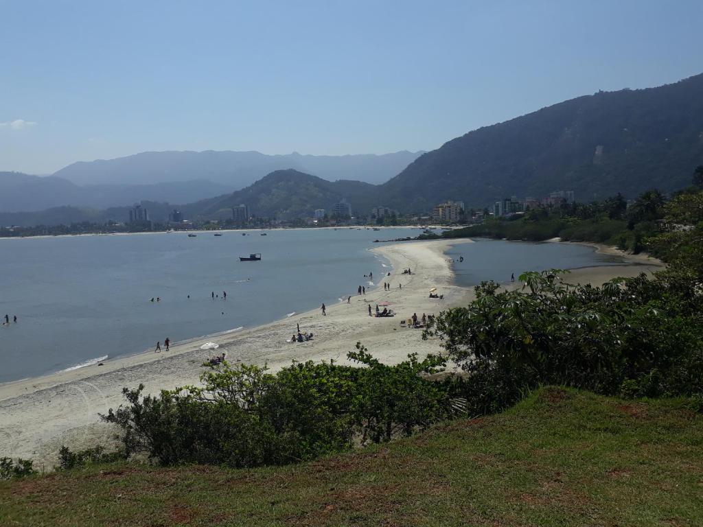 eine Gruppe von Menschen am Strand im Wasser in der Unterkunft CASA NO CENTRO DA CIDADE in Caraguatatuba