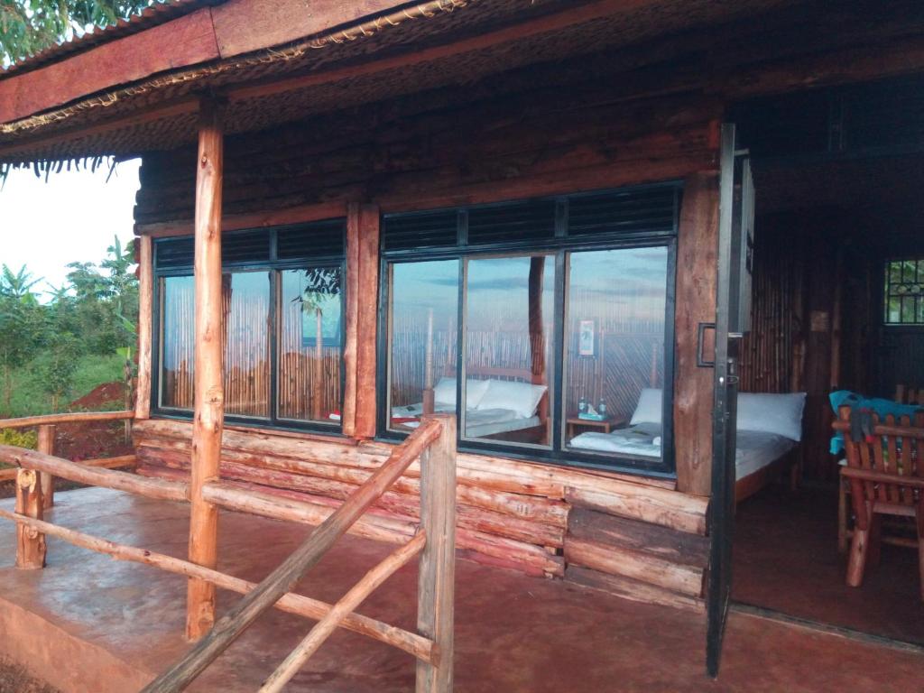 Cabaña de madera con dormitorio y balcón en Sipi Coffee Lodge en Kapchorwa