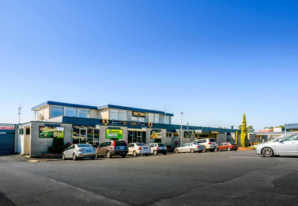 a parking lot with cars parked in front of a building at Top of the Town Hotel Motel in Burnie