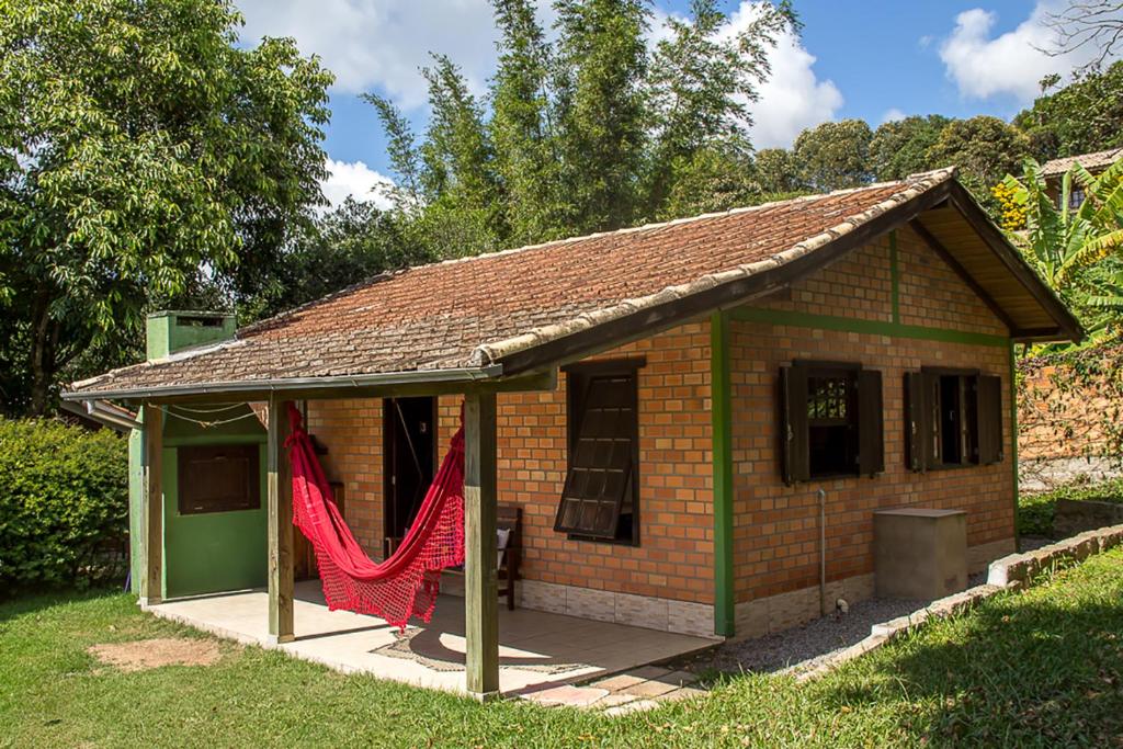 a small brick house with a red net at Cabanas Areias in Praia do Rosa
