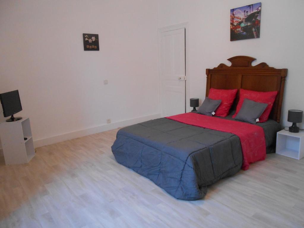 une chambre avec un grand lit avec des oreillers rouges dans l'établissement Maison Ancienne Rénovée Du XIXème à Partir de 1 à 10 personnes plus 2 bébés, à Saint-Aignan