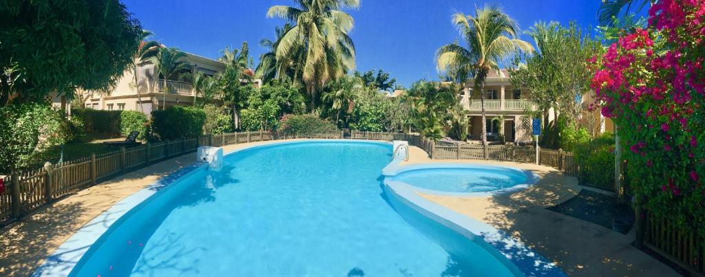 una piscina di fronte a una casa di Beachfront Villa in a beautiful and secured complex a Flic-en-Flac