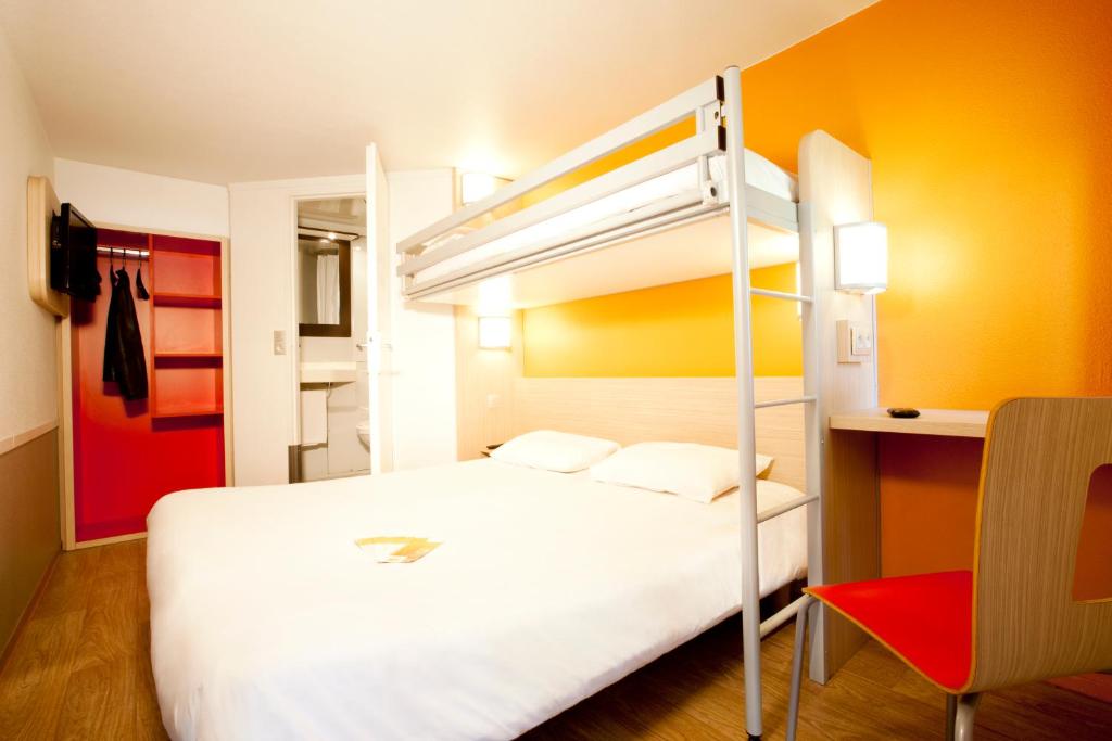 a bedroom with a bed and a bunk bed at Premiere Classe Villepinte Centre - Parc des Expositions in Villepinte