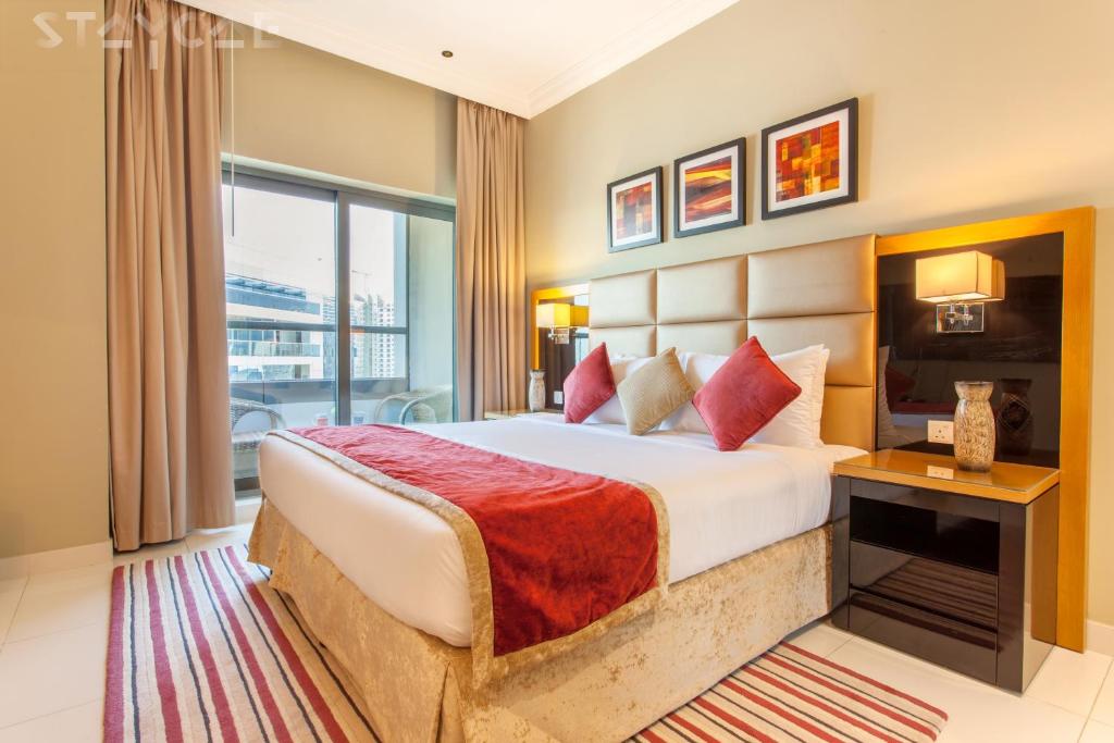 a hotel room with a large bed and a window at Staycae Holiday Homes - Capital Bay in Dubai
