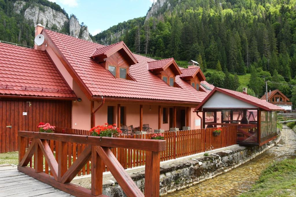 una casa con techo rojo y valla de madera en Chata PELC, en Stratená