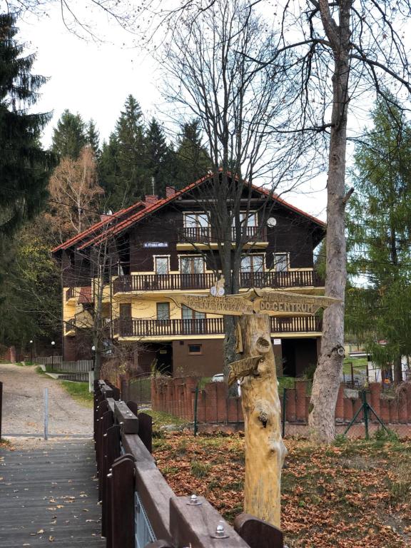 a large wooden house with a fence in front of it at Apartament Patryk in Szklarska Poręba