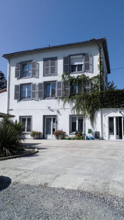 un grande edificio bianco con molte finestre di Chambres d'hôtes - Domaine Beau Sejour a Biaudos