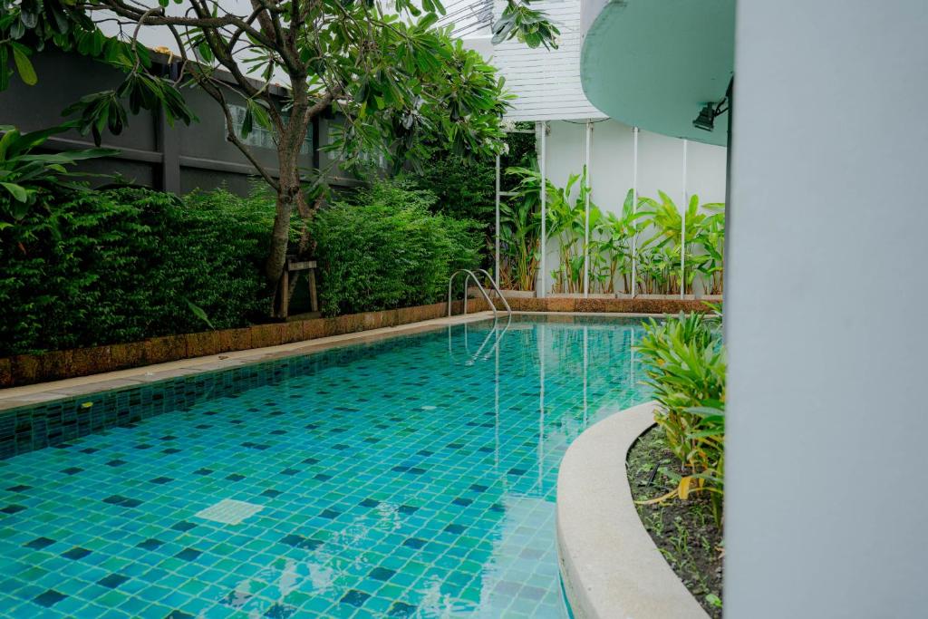 A curving outdoor pool sits within dense tropical landscaping.