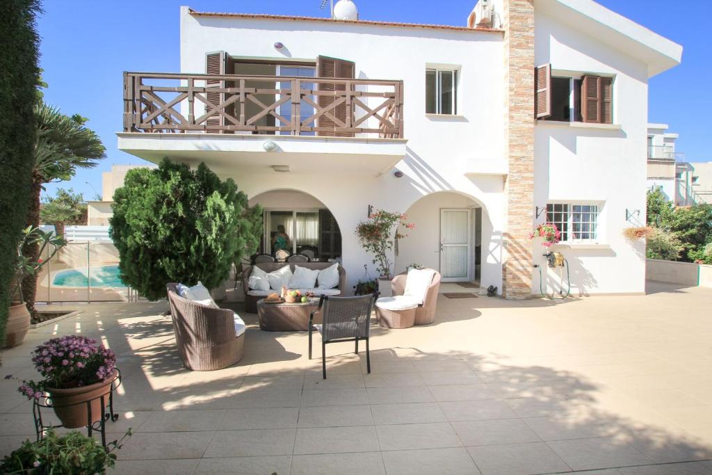 een huis met een balkon en een patio bij Villa Fig Tree in Protaras