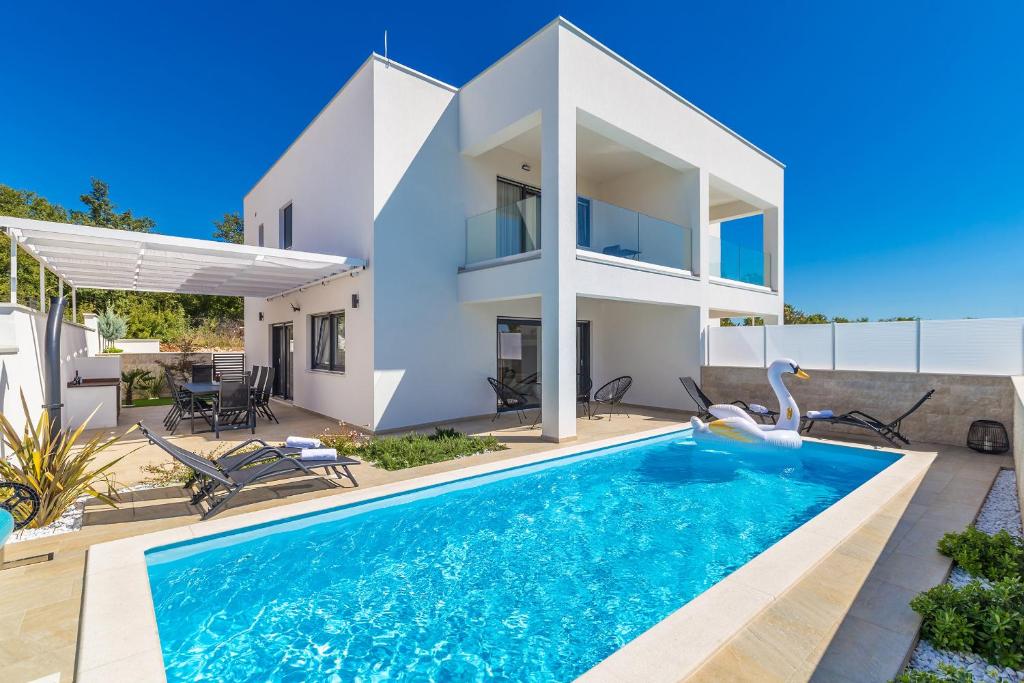 a villa with a swimming pool and a house at Villa Insula Aurea No.1 in Linardići