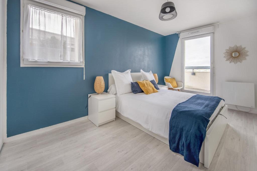 a blue bedroom with a bed and a window at Bel appartement de 2 chambres à 40 min de Paris in Courcouronnes