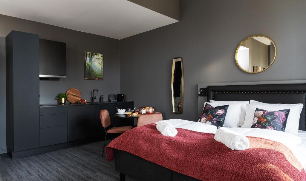a bedroom with a bed with a red blanket at Hotel Filip in Oslo