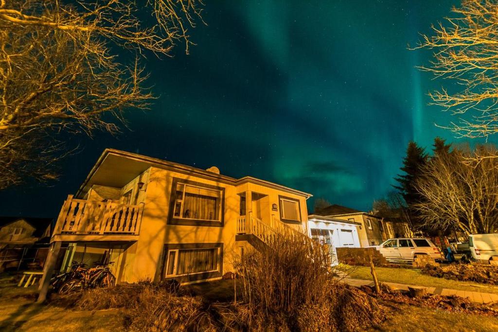 una casa con la aurora en el cielo en Guesthouse Henia Bed&Spas, en Selfoss