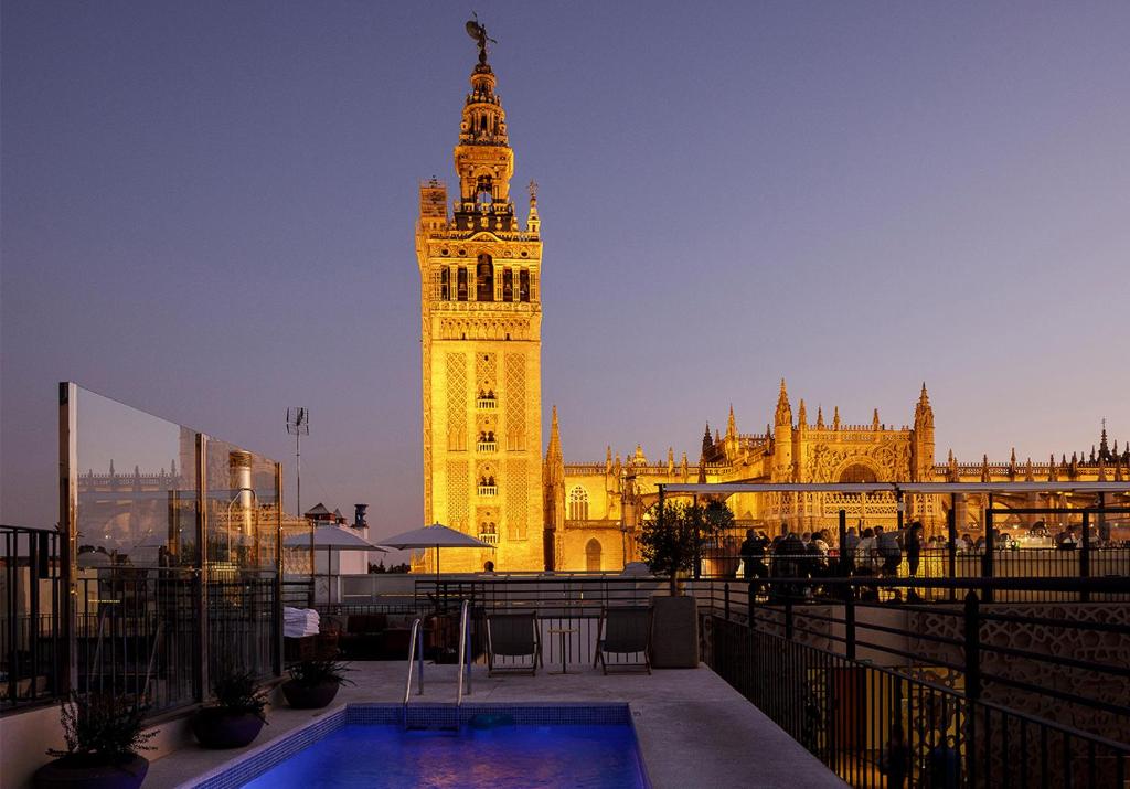un gran edificio con una torre de reloj delante de él en EME Catedral Mercer Hotel, en Sevilla