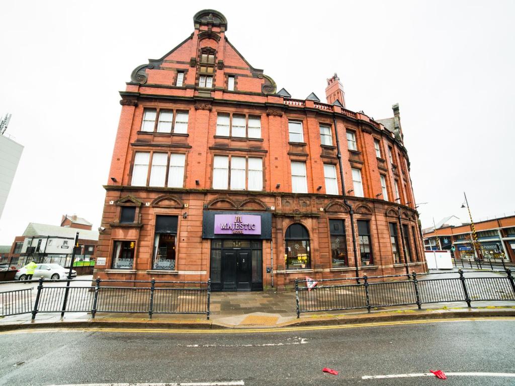 a large red brick building on the corner of a street at OYO Hotel Majestic in Barrow in Furness