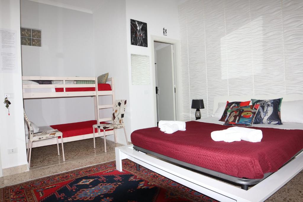 トラーパニにあるB&B Il Profumo del Portoのベッドルーム1室(赤いベッド1台、二段ベッド1組付)