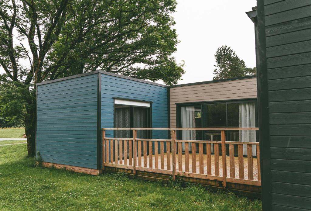 um barracão azul com um deque ao lado de uma casa em Terres de France - Le Domaine du Moulin Neuf em Rochefort-en-Terre