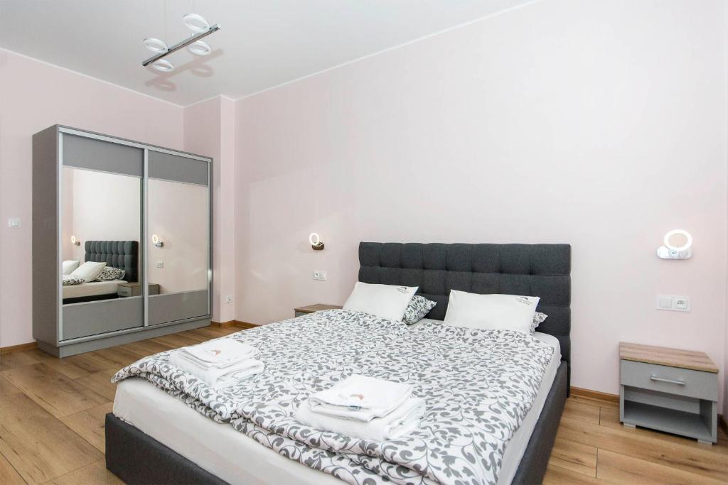 a bedroom with a large bed and a mirror at Apartament Amber z garażem moj-sopot pl in Sopot