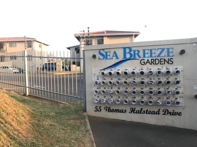 a sign for a ssea breeder gardens with a fence at Seabreeze Modern Apartment sleeps up to 4 people in Durban