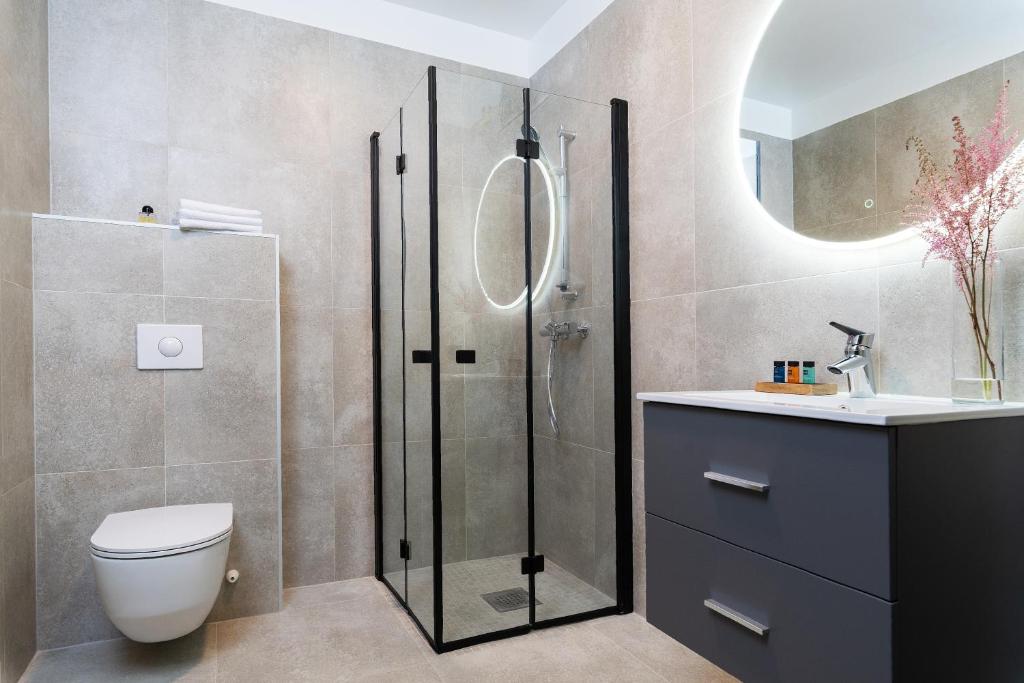 a bathroom with a shower and a toilet and a sink at Hotel Filip in Oslo