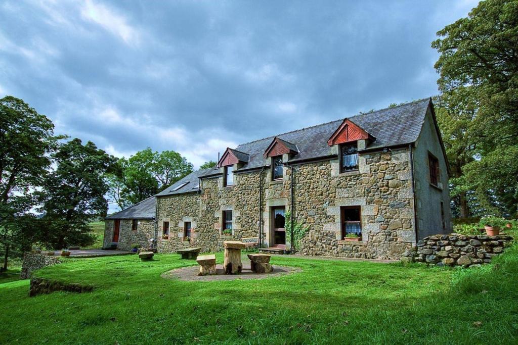 un gran edificio de piedra con un patio de césped en B&B Drum Farm, en Stirling