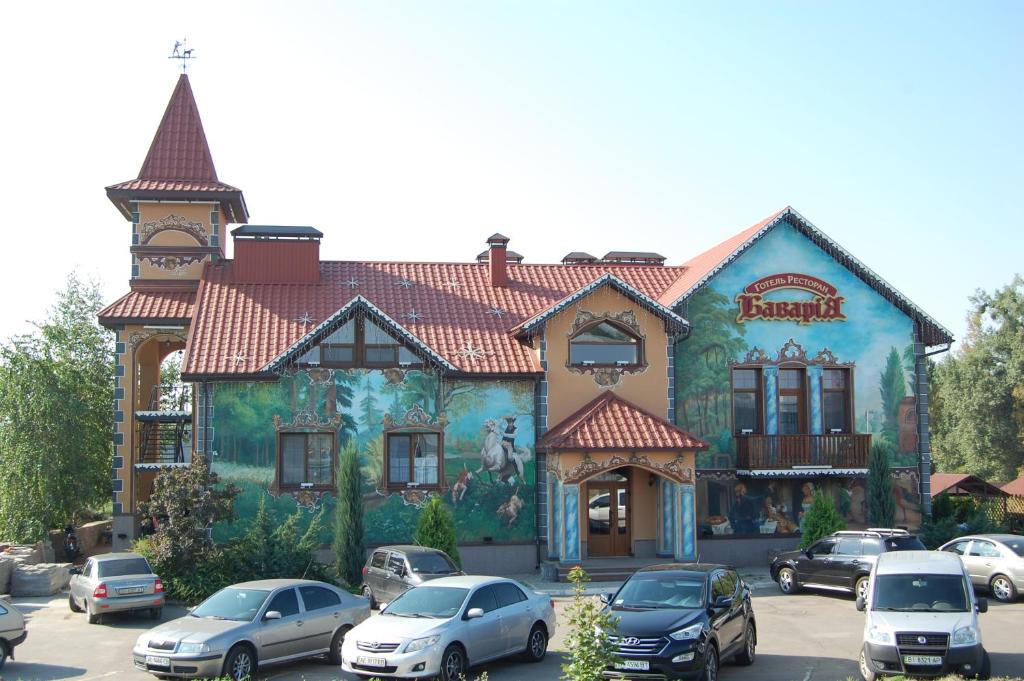 a large building with cars parked in front of it at Готель Баварія in Poltava