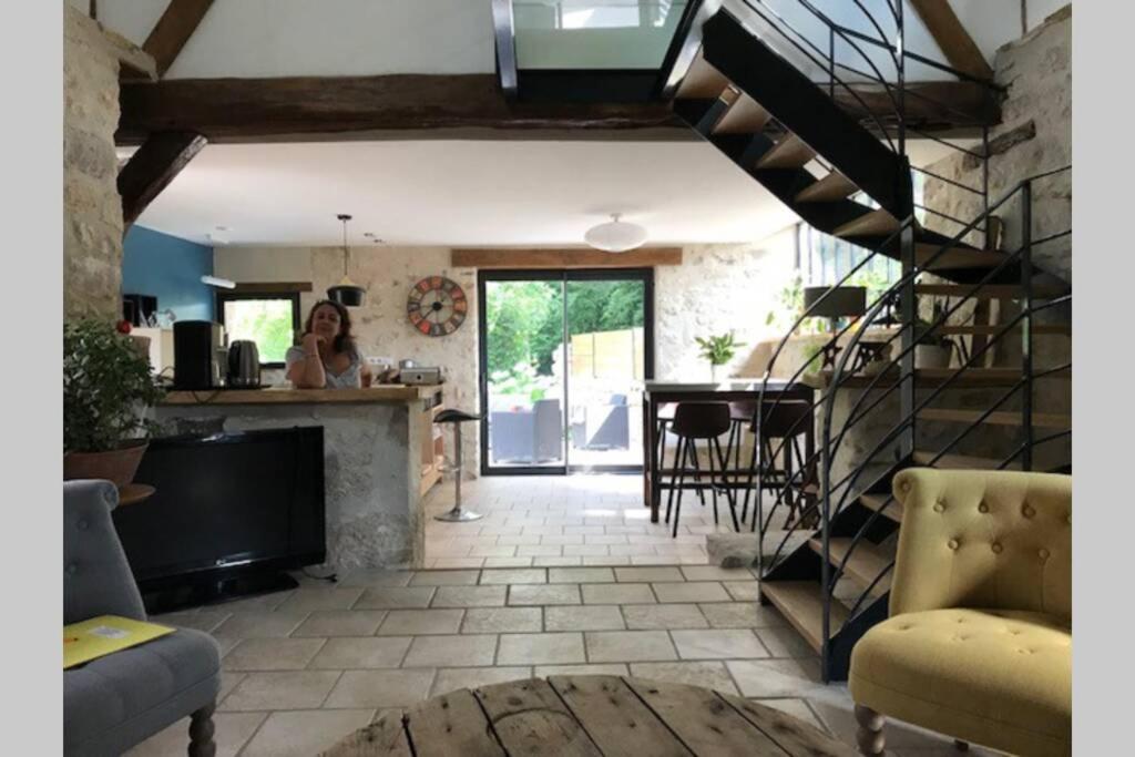 uma sala de estar com uma escada em espiral e uma cozinha em Le gite de l'auge em Auger-Saint-Vincent