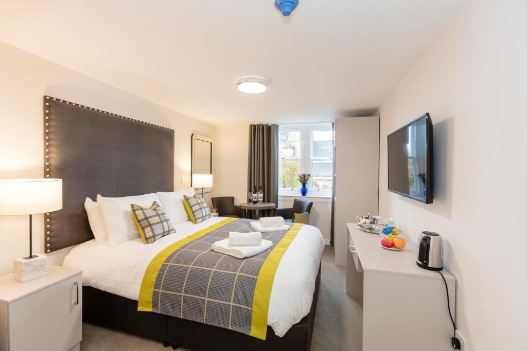 a bedroom with a king sized bed and a desk at Dalkeith ApartHotel in Dalkeith