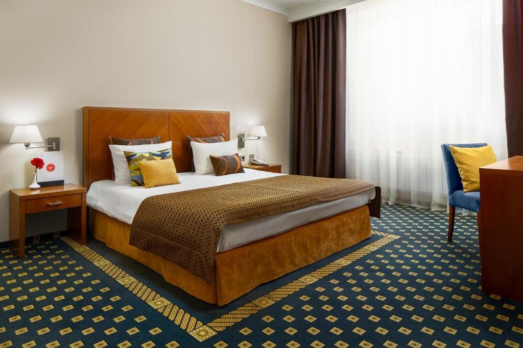 une chambre d'hôtel avec un lit et une chaise dans l'établissement Moskovskaya gorka by USTA Hotels, à Iekaterinbourg