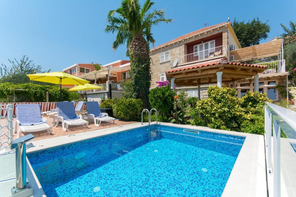 a swimming pool in front of a house at Apartments Green Harmony in Mlini