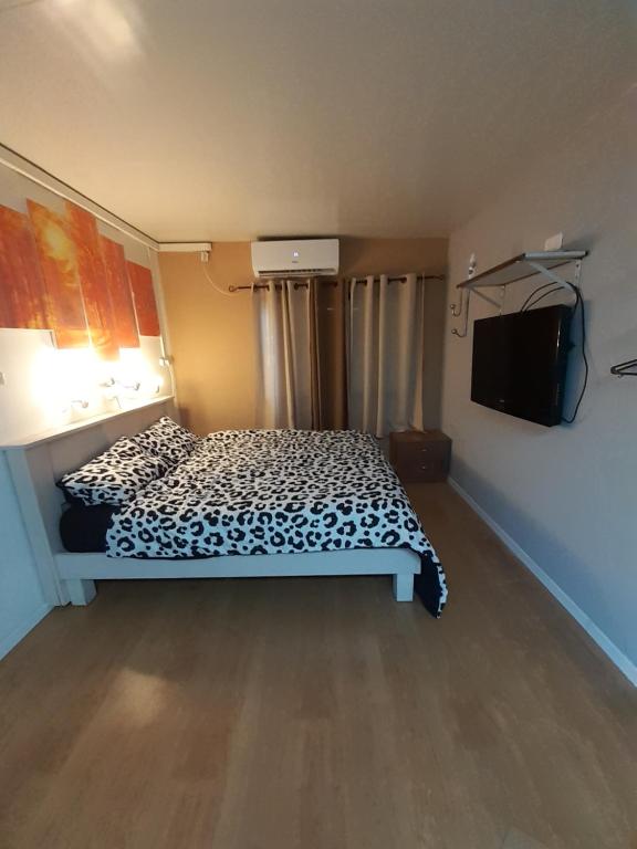 een slaapkamer met een bed en een flatscreen-tv bij Suite- Studio- Zimmer in Bet Sheʼan
