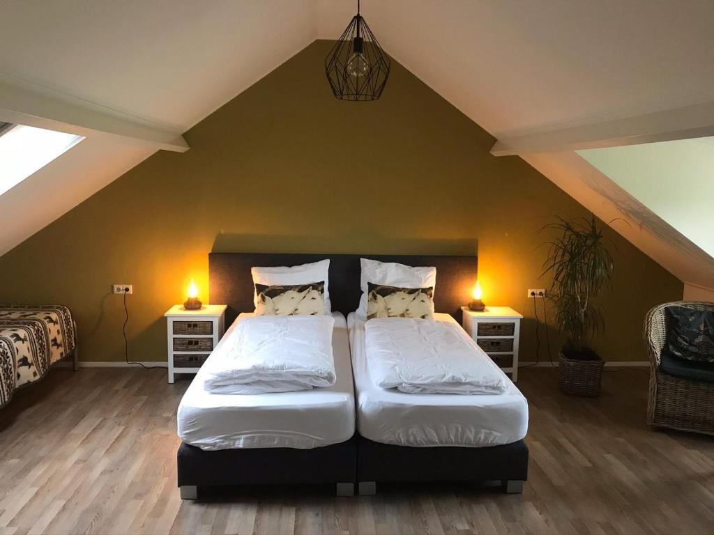 a bedroom with a large bed and two night stands at B&B de Rivierduin in Hattem