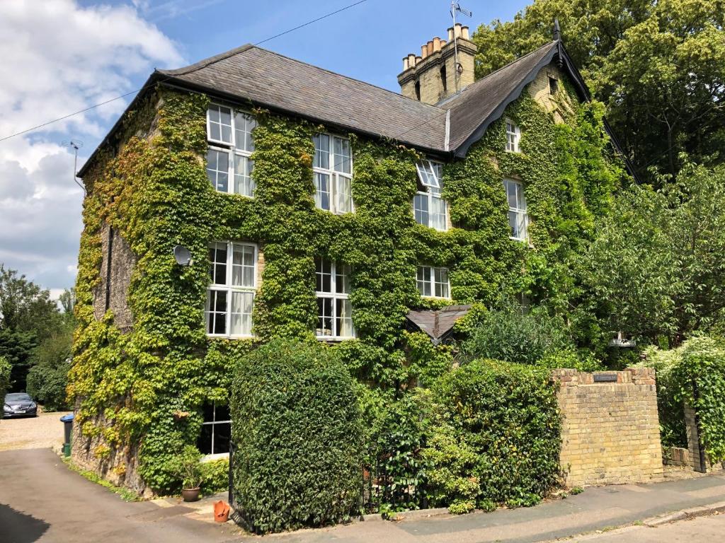 a building covered in ivy with a street at Pages Hotel and Guesthouse in Harlow