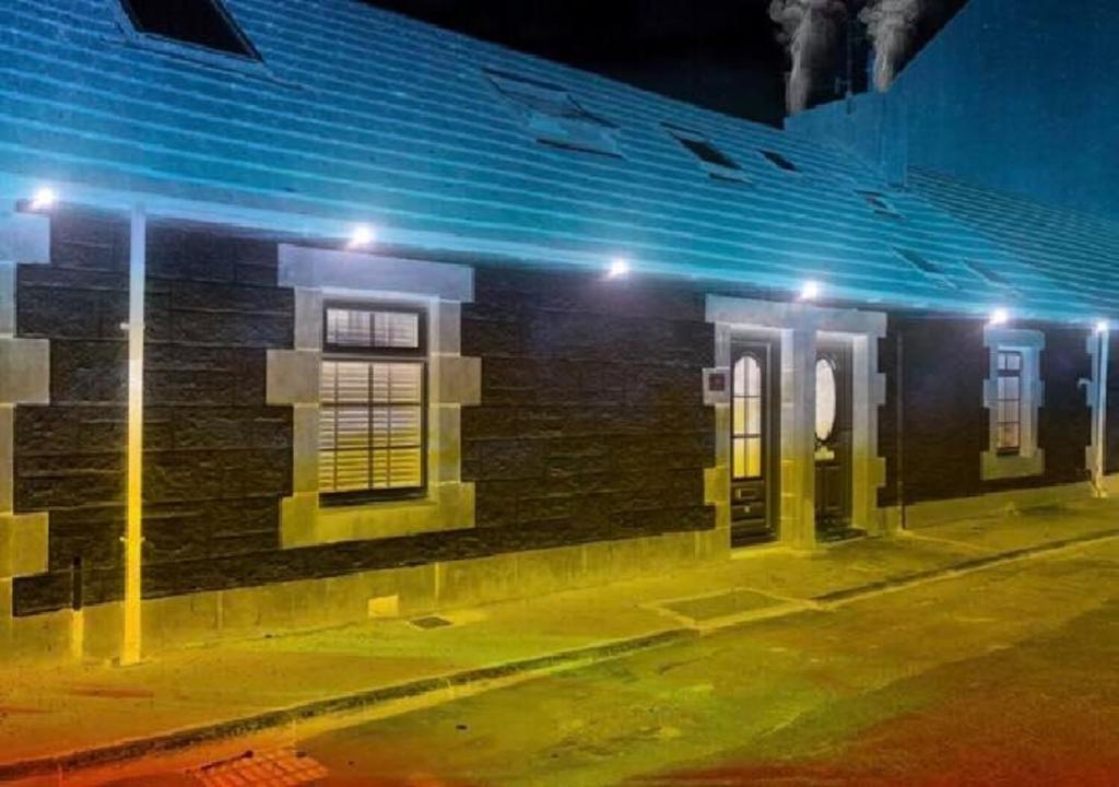 a brick building with lights on a street at night at Ayrshire Holiday Cottage in Girvan