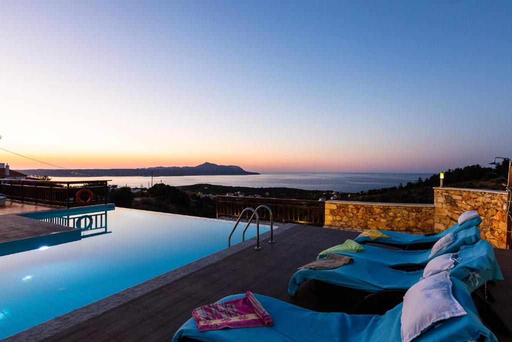 a swimming pool with blue tarps on top of a house at Ekaterini Vip Villa in Plaka