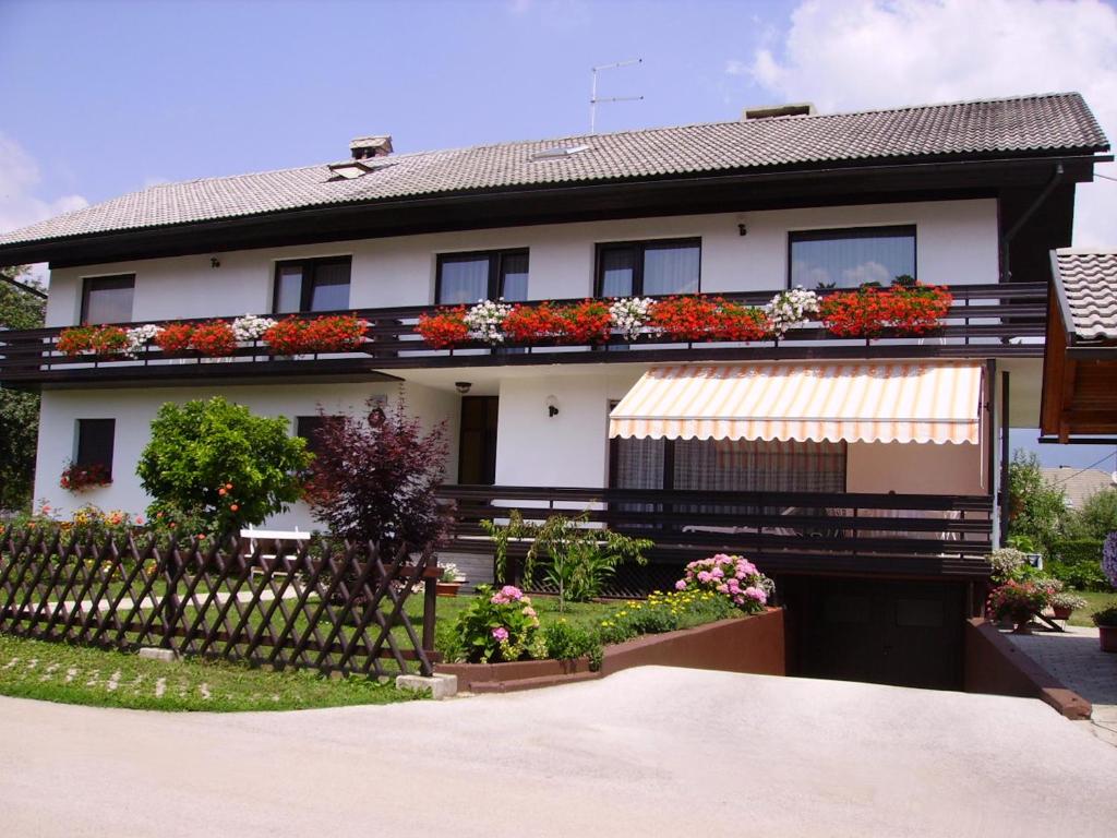 a house with flowers on the balconies and a fence at Apartments Fine Stay Bled in Bled