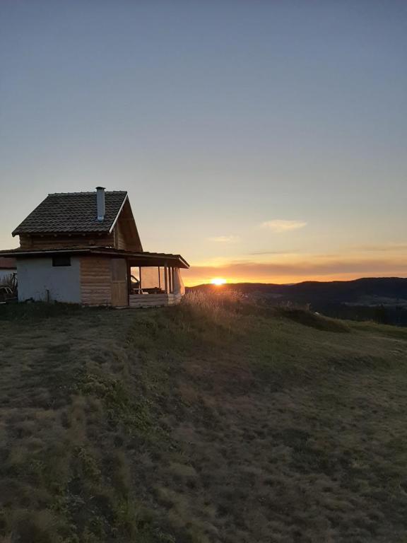 OrtsevoにあるВила Орцево Vila Ortsevoの日没を背景に丘の上の家