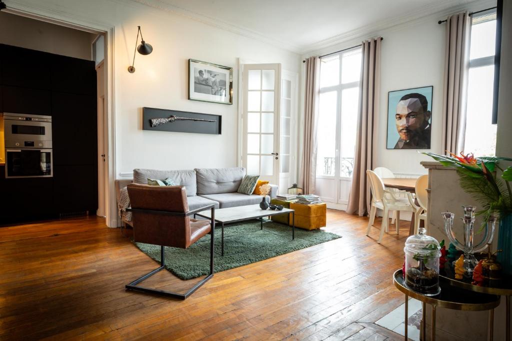 a living room with a couch and a table at L’Aristide in Reims