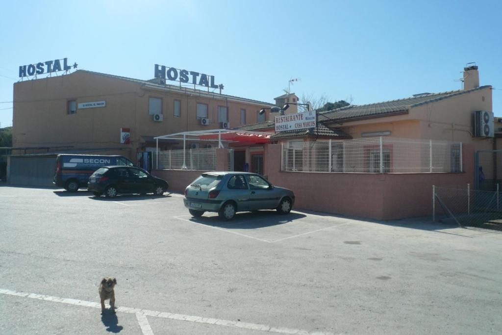 a dog standing in a parking lot in front of a hotel at Hostal El Rincón - Casa Marcos in Yepes