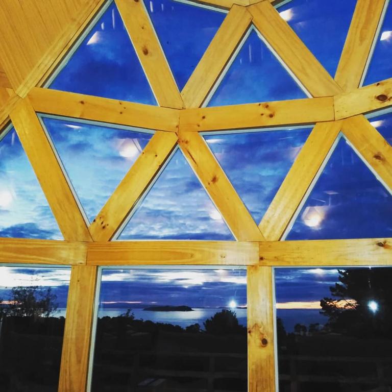 a window in a cabin with a view of the sky at domoschiloe in Ancud