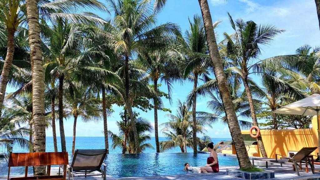 a woman and a child in the swimming pool at a resort at Vida Loca Sunset Beach Resort in Phú Quốc