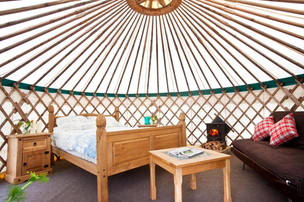 a room with a bed and a table in a yurt at Portsalon Luxury Camping in Portsalon